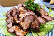 Cooked BBQ Pork aka Char Siu slices on a plate 
